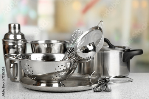 Fotomural Stainless steel kitchenware on table, on light background