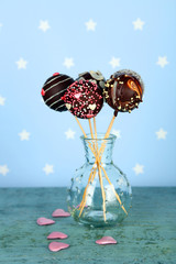 Wall Mural - Tasty cake pops on blue background