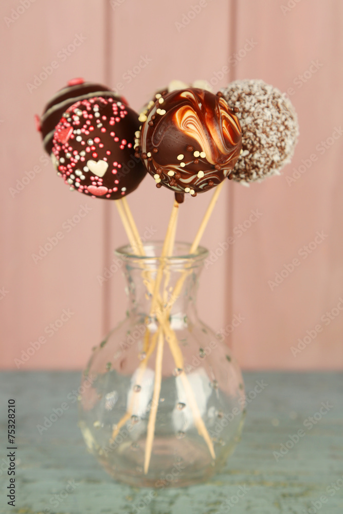 Tasty cake pops on wooden background