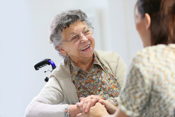 Elderly woman sharing good time with home carer