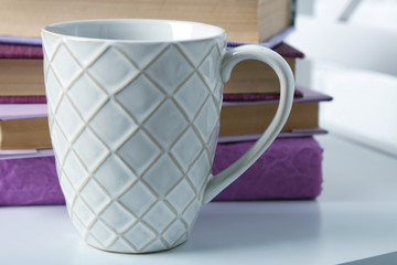 Sticker - Pile of books with cup on the chair on brick wall background