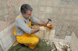© sima - Home renovation, worker demolish tiles in a bathroom