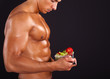 © cristovao31 - Fitness man holding a bowl of fresh salad on black background