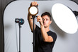 © lightpoet - Young pro photographer in his studio setting up lights