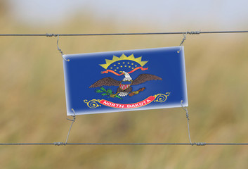 Border fence - Old plastic sign with a flag