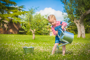 Wall Mural - Little gardiner on the green grass in a summer day