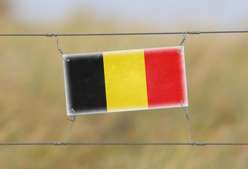 Wall Mural - Border fence - Old plastic sign with a flag