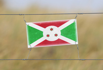 Wall Mural - Border fence - Old plastic sign with a flag