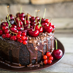 Wall Mural - Chocolate cake with cherries on wooden background