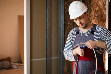 Electrician working with wires in new apartment