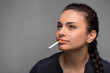 Woman smoking a cigarette on black background