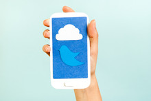 Conceptual Phone Showing A Cloud And Bluebird On Blue Background