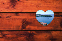 Heart Shaped Hole With Sea And Island In Wooden Wall.