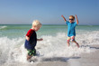 Two Young Children Playing and Splashing in Ocean Water