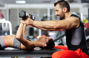 Wall Mural - Fitness instructor assisting young woman