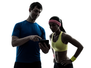 woman exercising fitness  man coach using digital tablet  silhou