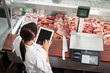 Butcher Using Digital Tablet In Butchery