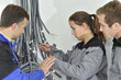 Professional electrician with students on construction site