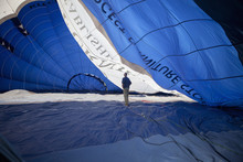Man Standing Inside A Partially Inflated Hot Air Balloon.