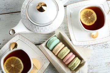 Wall Mural - Colorful macaroons with teapot and cup of tea