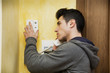 © theartofphoto - Young man answering the intercom in an apartment