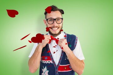 Composite image of geeky hipster wearing christmas vest