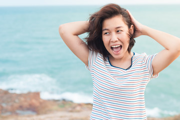 Young happy woman near the ocean background.