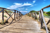 Fototapeta Pomosty - wooden boardwalk heading to the beach