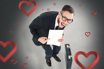 Poster - Composite image of geeky smiling businessman showing paper
