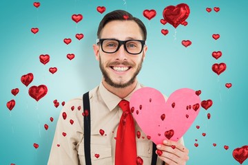 Poster - Composite image of geeky hipster smiling and holding heart card