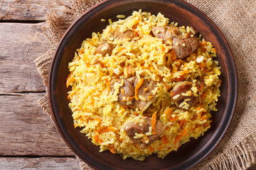 Asian pilaf on a brown plate closeup. horizontal top view