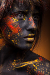 Wall Mural - dark portrait of woman in black paint with yellow smudges