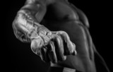 Fototapeta  - Handsome muscular bodybuilder demonstrates his fist and vein
