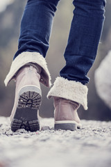 Wall Mural - Woman in boots hiking along a rural path