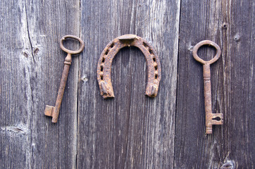 two old rusty historical key and luck symbol horseshoe on wall