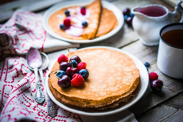 Wall Mural - Pancakes with berries on wooden background