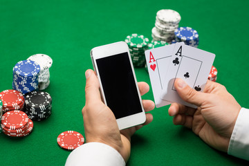 casino player with cards, smartphone and chips