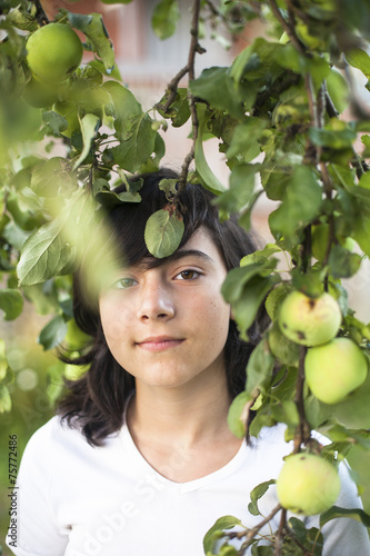 Fotografie, Tablou Dark-haired teen girl in the apple orchard.