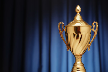 Wall Mural - gold cup on a dark blue background