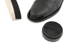 Black Leather Shoe With Brush And Polish On White Background