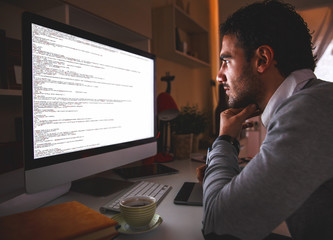 young male progammer working at home.
