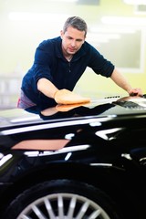 Wall Mural - Man worker polishing car on a car wash