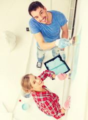 smiling couple painting wall at home