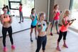 group of women exercising with dumbbells in gym