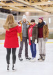 © Syda Productions - happy friends taking photo on skating rink