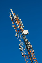 Communications tower with antennas on blue sky