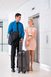 Paar bei Anreise in Hotellobby mit Koffer