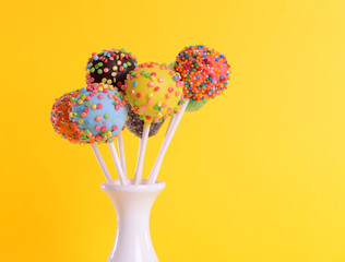 Sticker - Sweet cake pops in vase on yellow background