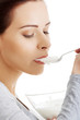 © Piotr Marcinski - Portrait of healthy woman eating natural yoghurt