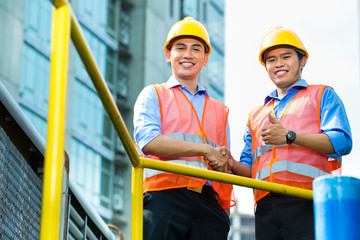 Asian Indonesian construction workers on building site